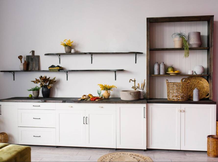A Scandinavian-style kitchen interior in white and brown tones, featuring a balanced mix of open shelving vs. cabinet with shelves.