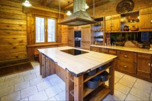 Kitchen interior with natural wood cabinets and a marble-top island with a sink space