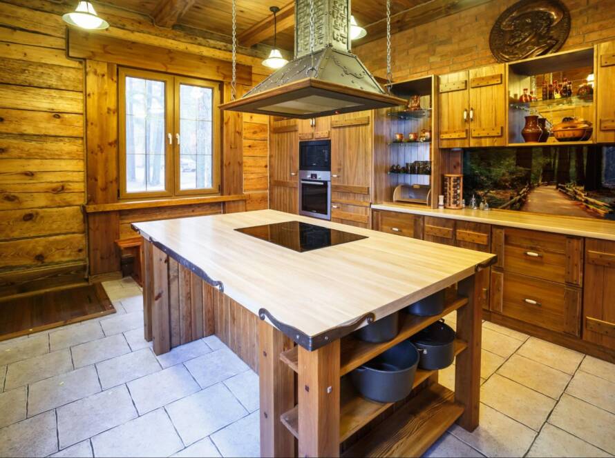 Kitchen interior with natural wood cabinets and a marble-top island with a sink space