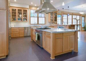 Elegant kitchen interior showcasing custom wooden cabinetry, a spacious center island, and a prominent wooden range hood centerpiece