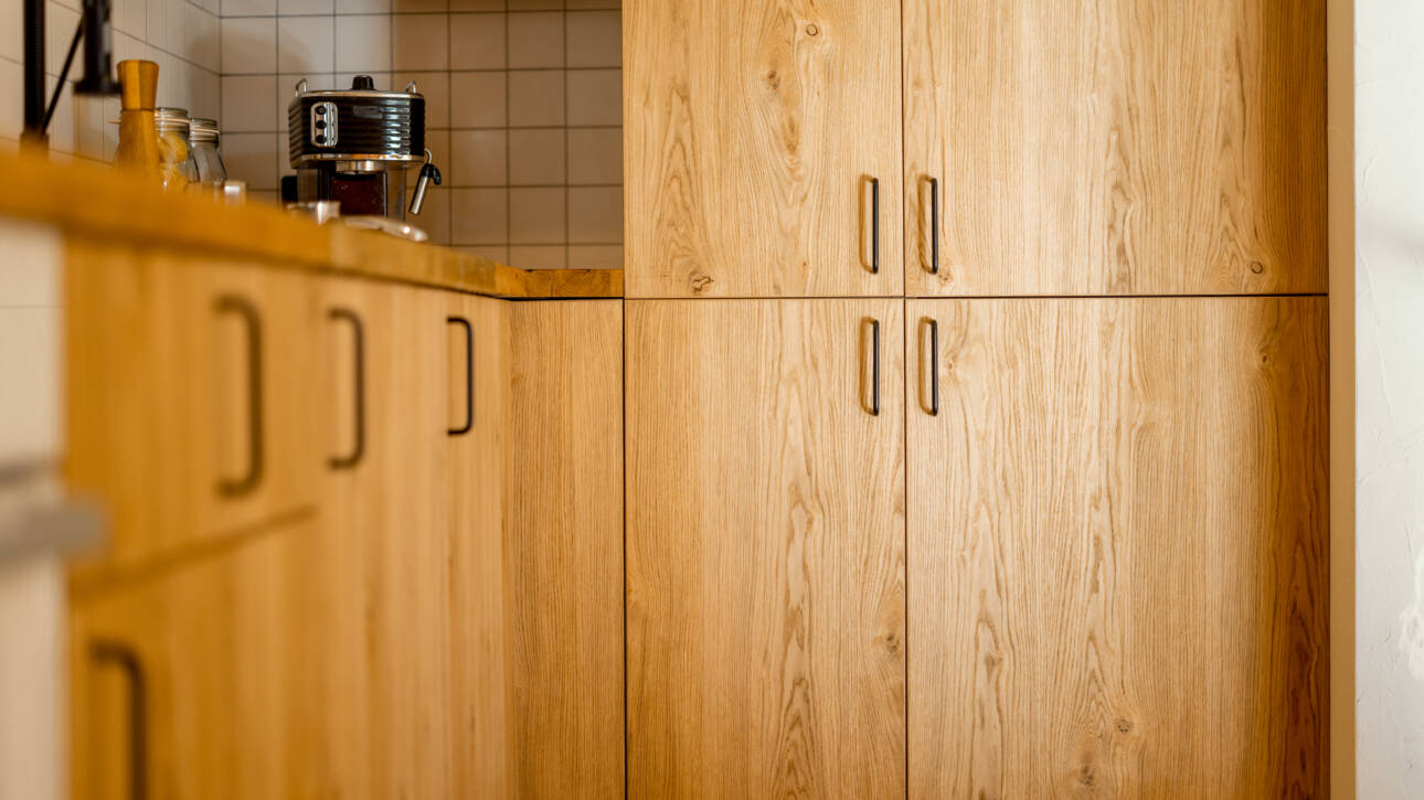 A kitchen interior styled with natural wood-colored cabinets.