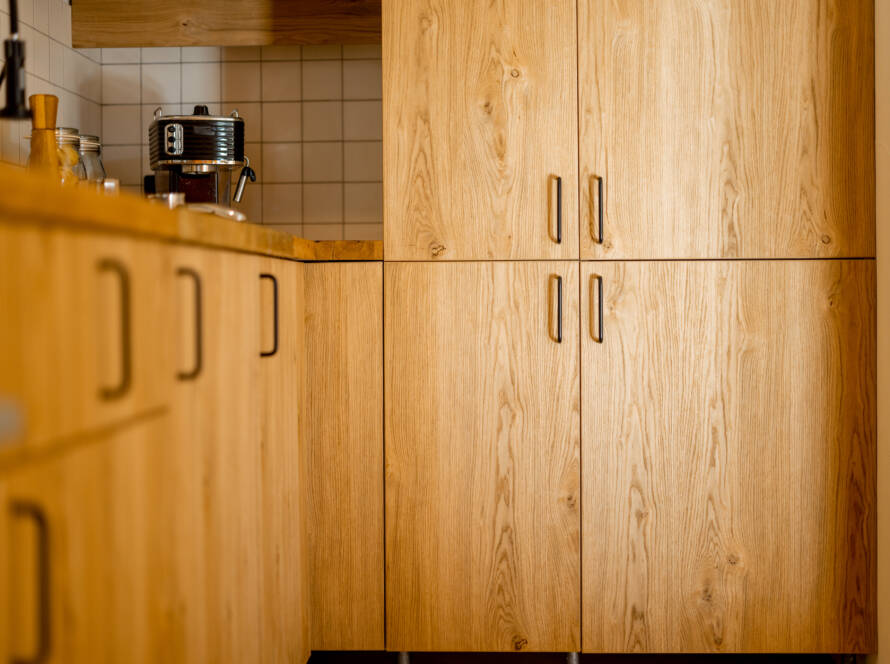 A kitchen interior styled with natural wood-colored cabinets.